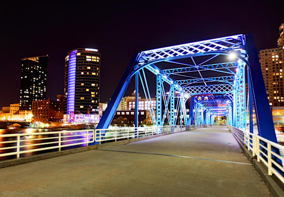 A bridge with blue lights is lit up at night.