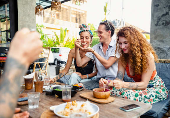 A group of people enjoying a meal together at an outdoor restaurant.