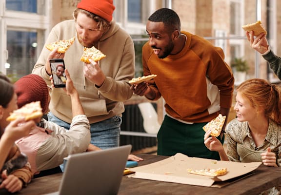 A group of people enjoying pizza together in a casual setting.
