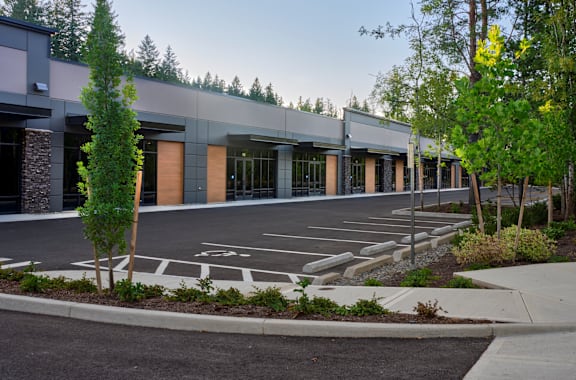 a parking lot in front of a building with trees