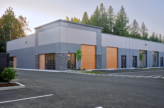 a modern building with a parking lot and trees