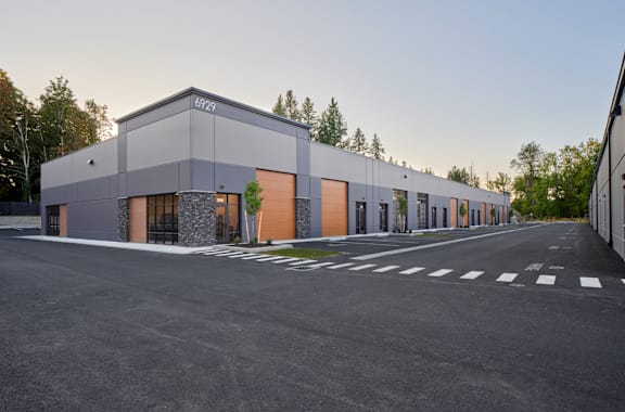 a modern building with orange doors and a parking lot