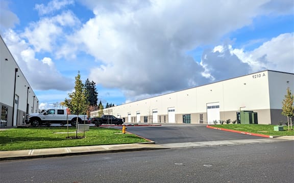 a large white building with a truck parked in front of it