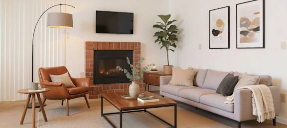 A living room with a fireplace, a couch, a chair, and a coffee table.