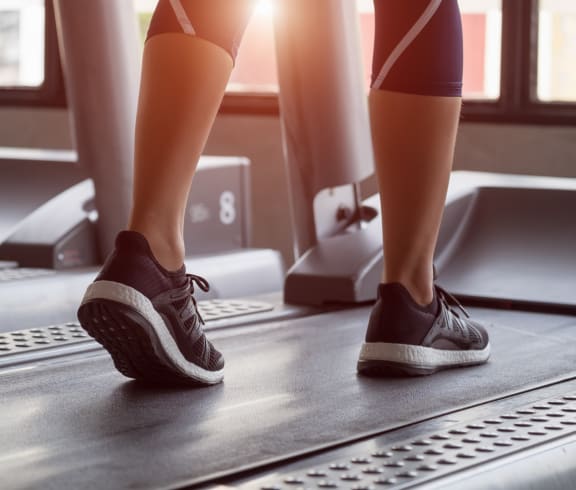 a woman walking on a treadmill in a gym