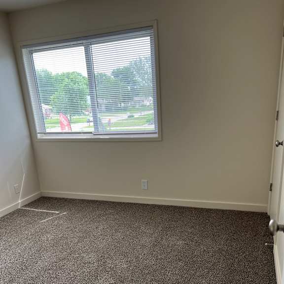 a window in a corner of a room with a cement wall
