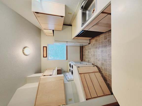 a kitchen with wooden cabinets and a stove and a sink