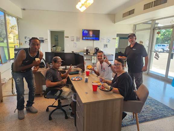 A group of people are gathered around a table eating food.