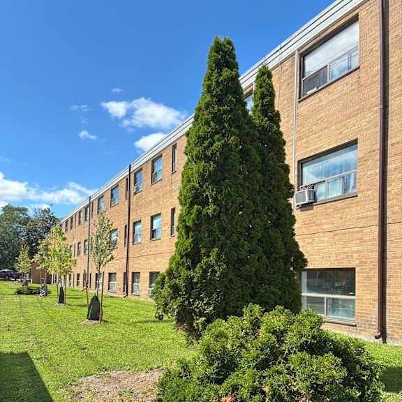 A tall building with a green lawn in front of it.