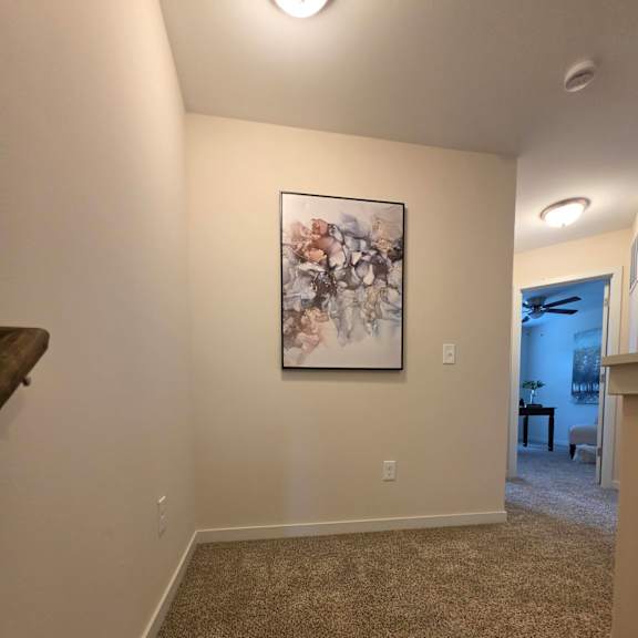 A painting hangs on a wall above a staircase.