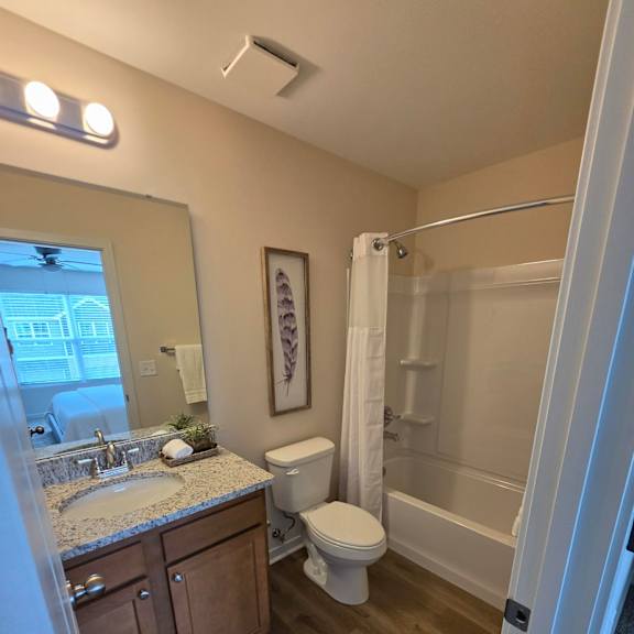 A bathroom with a toilet, sink, and mirror.