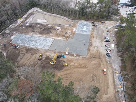 an aerial view of a construction site with machinery and trees