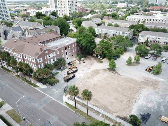 a large dirt mound sits in the middle of a street in front of a large brick building