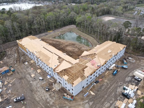 an aerial view of a building under construction with a pool