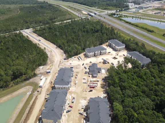 an aerial view of a building under construction next to a highway