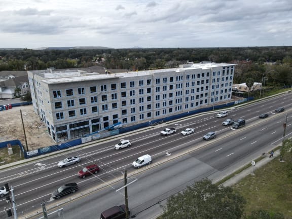 an aerial view of a large white building next to a highway