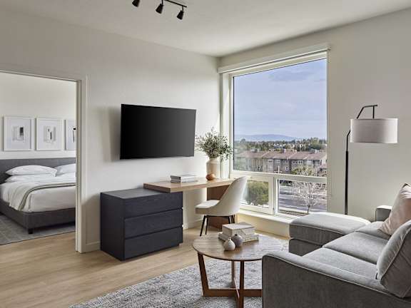 A modern living room with a large window overlooking a cityscape.