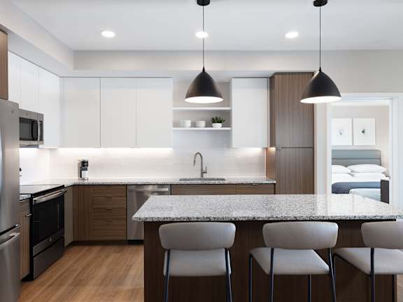 a kitchen with an island and chairs in front of a counter top