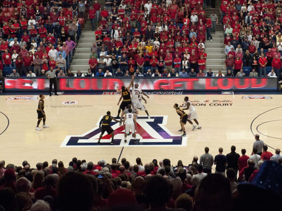 a crowd of people watching a basketball game in a stadium