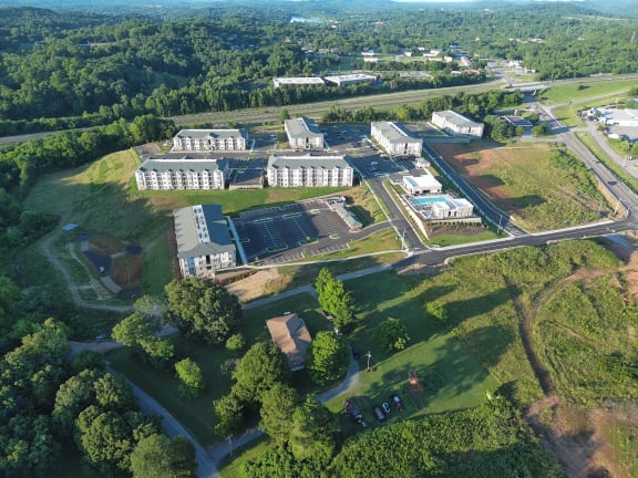 an aerial view of the campus with buildings and a green field