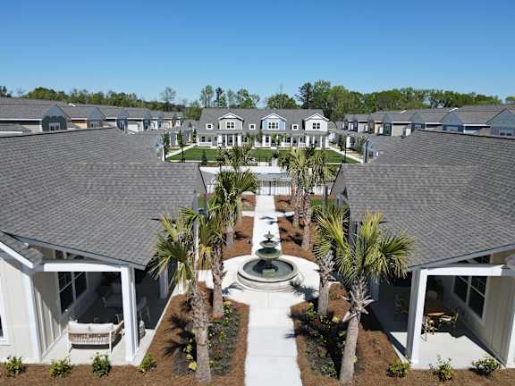 A row of houses with a fountain in the middle of the front yard. at Allier Port Wentworth Apartments, Port Wentworth 31407