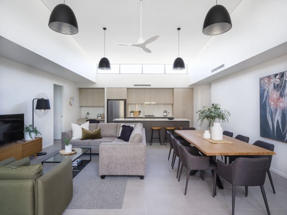 a living room and kitchen with a wooden table and chairs