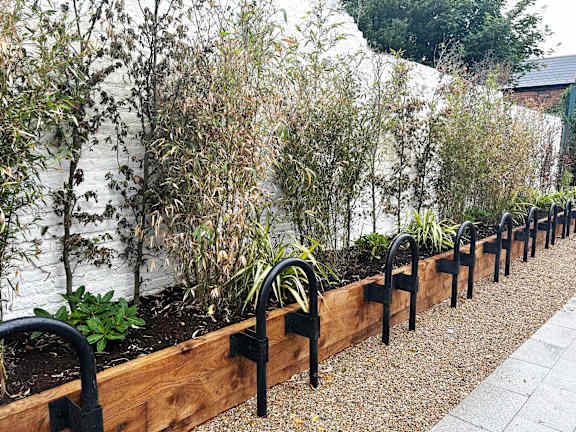 a long wooden retaining wall with plants in it