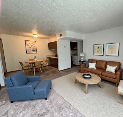 A living room with a blue couch, a wooden coffee table, and a lamp.