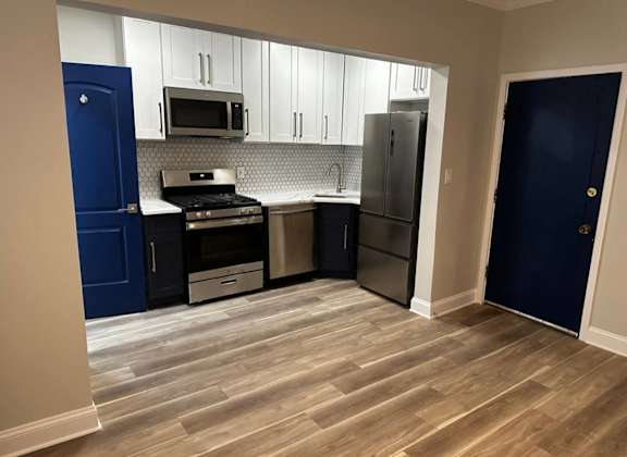 A kitchen with a blue door and a stove top oven. at Evelyn Apartments, Oak Park, IL, 60304