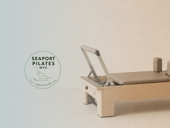 A wooden seaport pilates machine is on a white background.