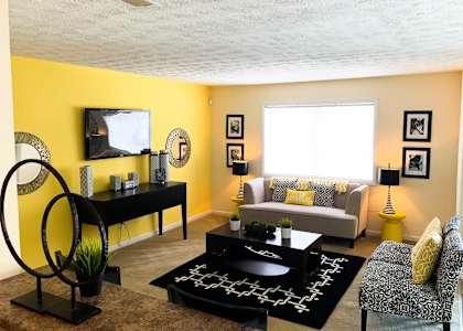 A living room with a yellow wall and a television.