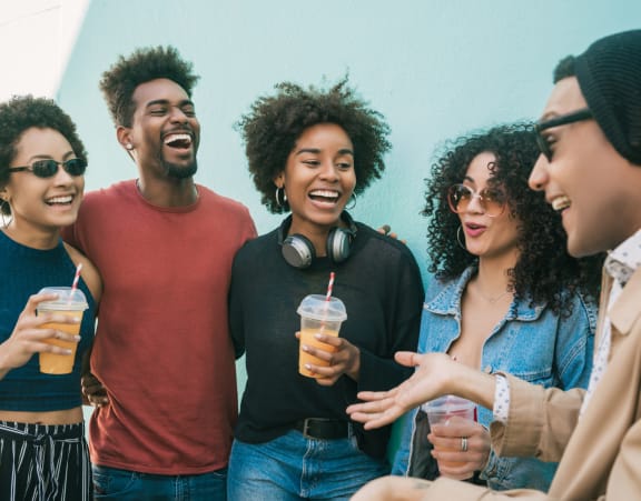 a group of friends are laughing and talking and drinking drinks