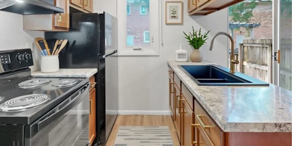 A kitchen with black appliances and wooden cabinets.