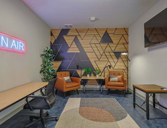 A modern office space with a geometric patterned wall and a neon sign that reads  at The Virginia Apartments , Texas, 78155