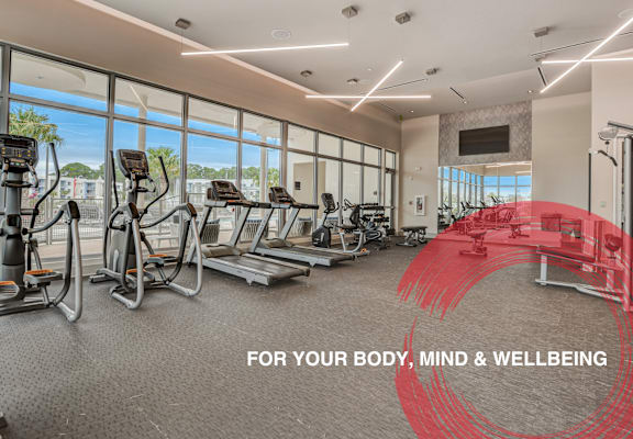 a gym with cardio equipment and windows with a view of the city at Icon One, Daytona Beach, FL, 32114