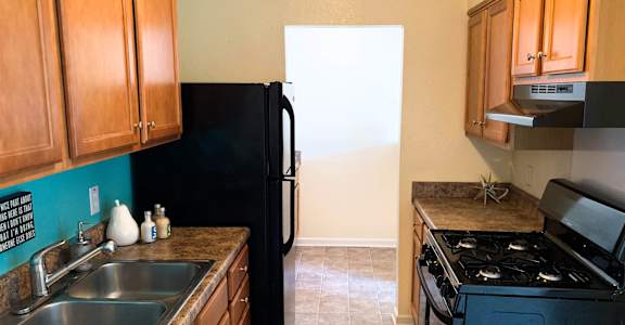 A kitchen with a black fridge and stove.