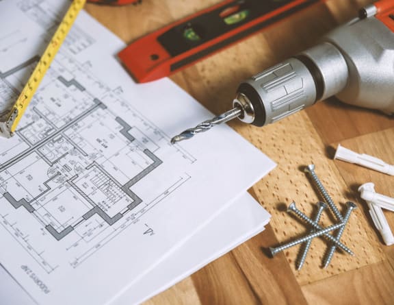 a drill and a piece of paper on a table with tools