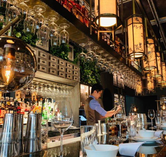 a bartender stands behind the bar at a restaurant
