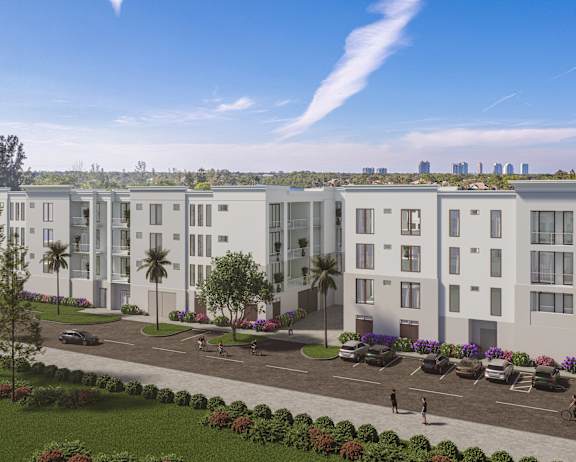 A row of modern townhouses with a park in front and a city skyline in the background.