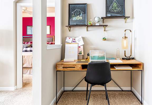 a home office with a wooden desk and a black chair