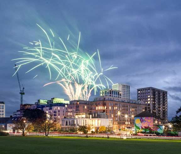A firework display illuminates the sky above a cityscape.