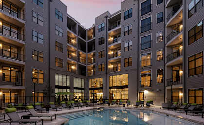 an apartment building with a pool at dusk