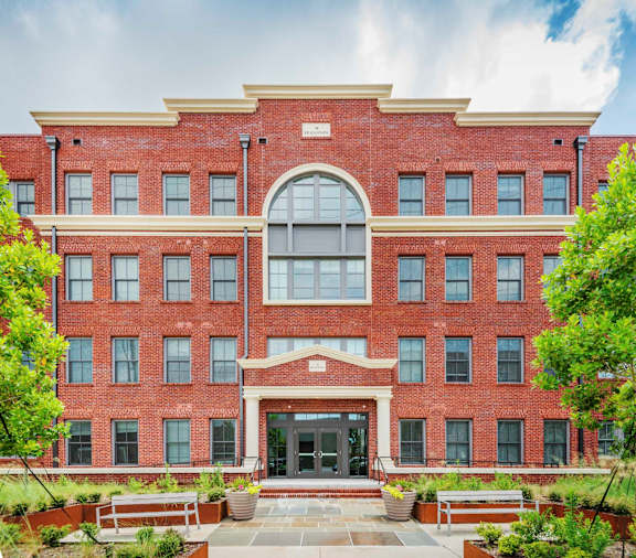 A red brick building with a large arched window and a small porch.