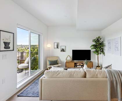a living room with a couch and a tv and a balcony