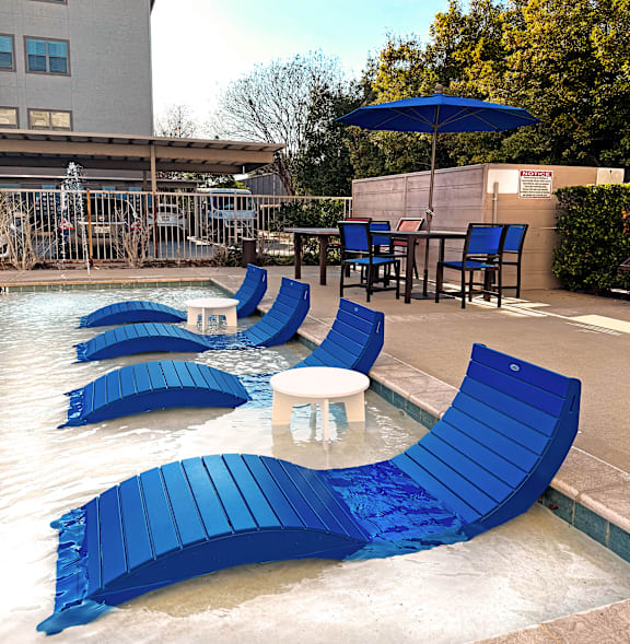 Blue chairs are arranged around a pool.