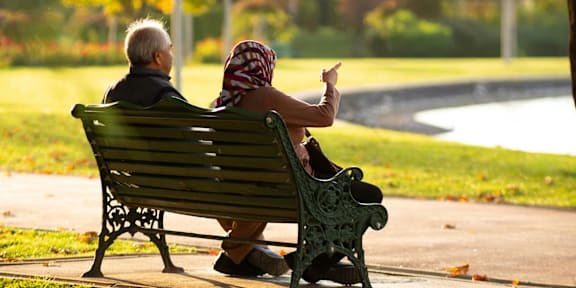 A man is giving a treat to a dog at a table.