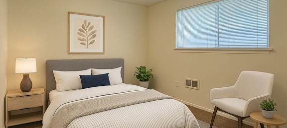 A bedroom with a bed, chair, and lamp.