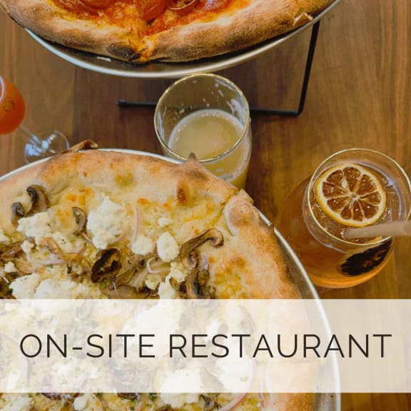 a slice of pizza on a table at a restaurant with glasses of beer