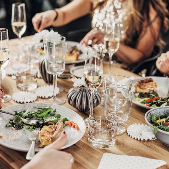 A table set for a meal with plates of food and glasses of water.
