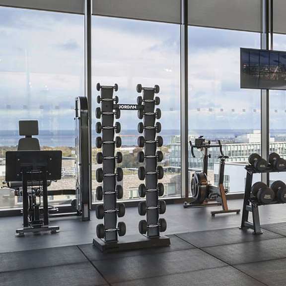 A gym with a Jordan branded weight stack in the middle of the room.